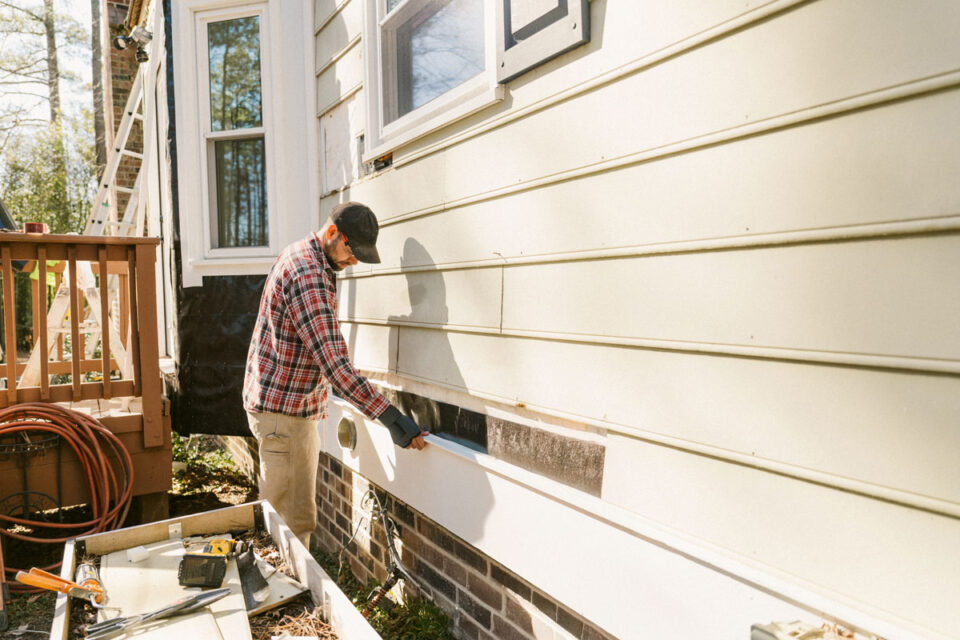 Construction worker repairing a house siding